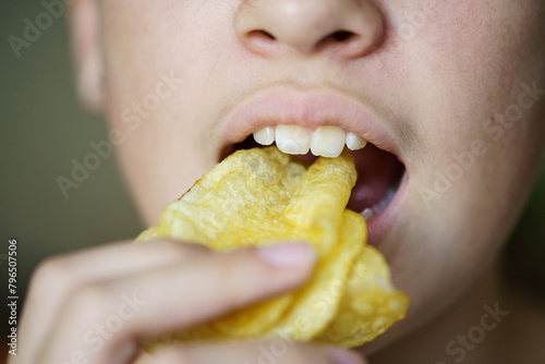 Crop unrecognizable girl eating crunchy potato chips