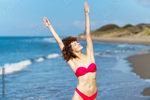 Happy woman in swimwear enjoying freedom at beach