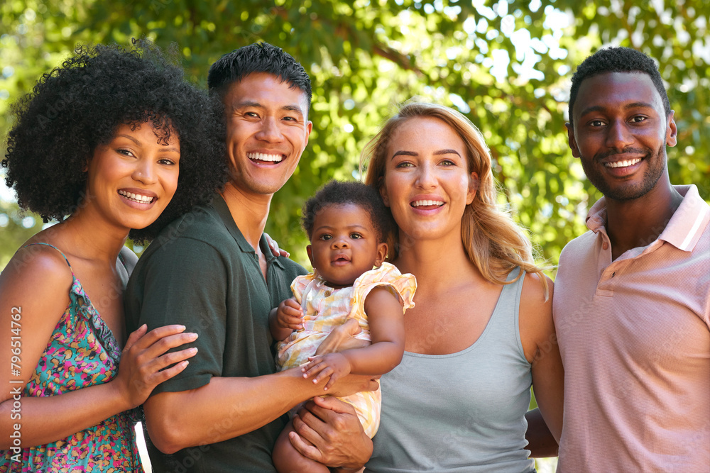 Portrait Of Multi-Racial Family And Friends Hugging Baby Outdoors In Countryside In Group Together Portrait Of Multi-Racial Family And Friends Hugging Baby Outdoors In Countryside In Group Together
