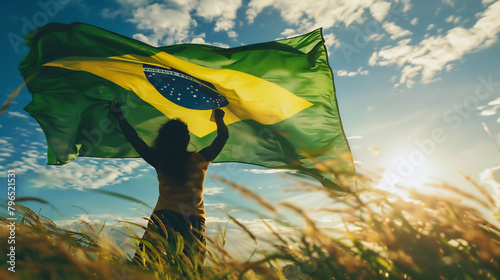 A person holding the Brazilian flag, viewed from the back, symbolizing patriotism and national pride. photo