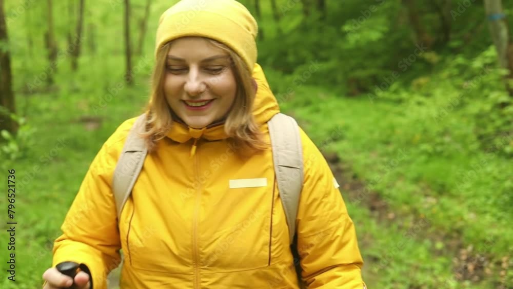 Lonely hiker traveler woman with backpack hiking the forest path to a mountain lake. Travel girl looking at distance. Female explores new places. High quality FullHD footage