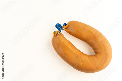 A farinheira is a Portuguese sausage made of pork fat, flour, paprika, and garlic. This stock photo shows a single farinheira on a white background, emphasizing its distinct color and texture. photo