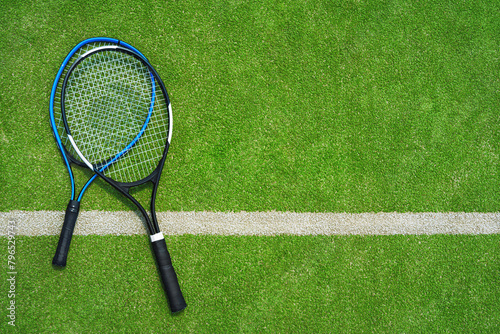  A yellow tennis ball and tennis racket lies on the clay court.