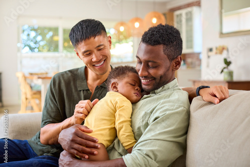 Konstfotografi Same Sex Male Couple Or Friends Cuddling Sleeping Baby Daughter On Sofa At Home