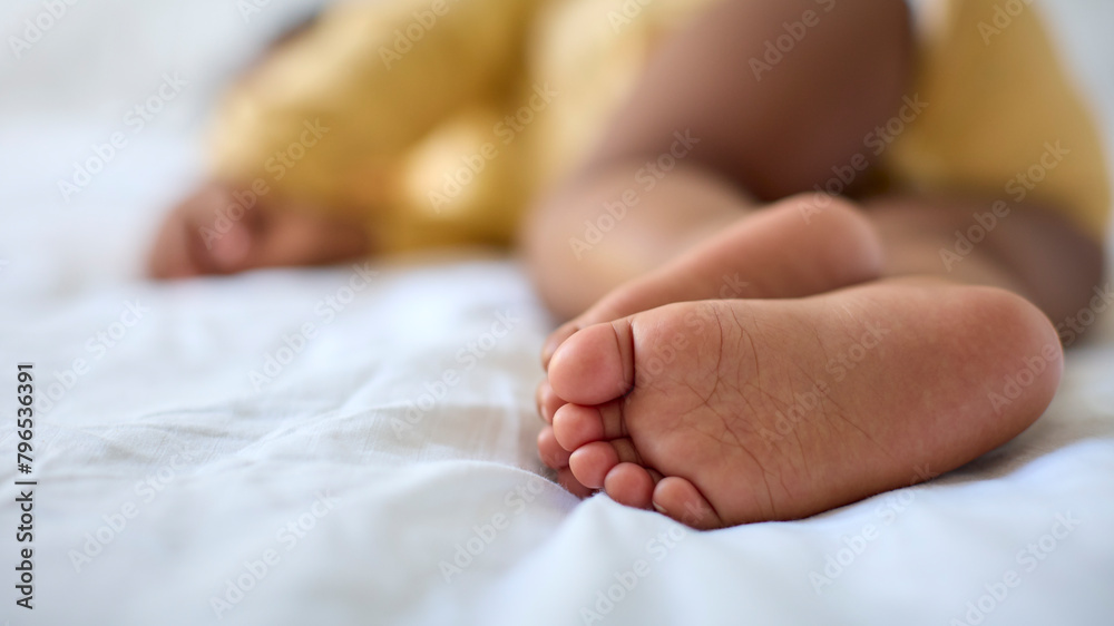 Close Up Of Feet Of Sleeping Baby Girl Lying On Parent's Bed At Home Close Up Of Feet Of Sleeping Baby Girl Lying On Parent's Bed At Home