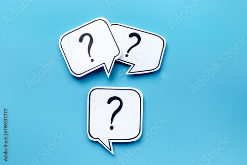 Question marks on paper speech bubbles, top view. Ask and answer concept