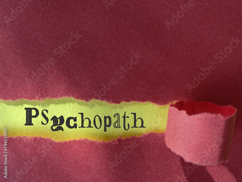 Psychopath text behind torn paper background. Stock photo.