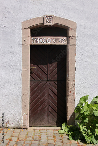 Wooden door in a neoclassical portal with date in roman numerals on a house in Kronenburg, Eifel region in Germany photo