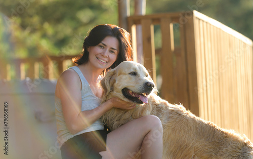 Girl Petting Golden Retriever Dog And Looking Into The Camera