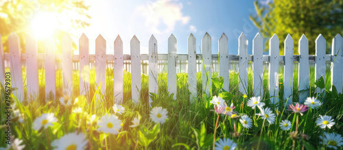 Classic White fence and green grass and flowers on sunny countryside spring landscape, background with copy space, template for montage. © SnowElf