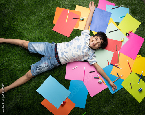 Cute Indian kid with art or drawing material like craft and paper colors 