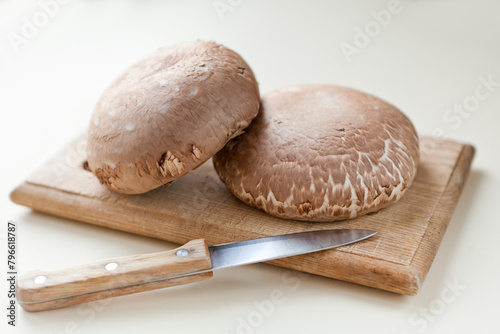 Fresh mushrooms on wooden table. portobello mushrooms brown mushrooms and cutting board.