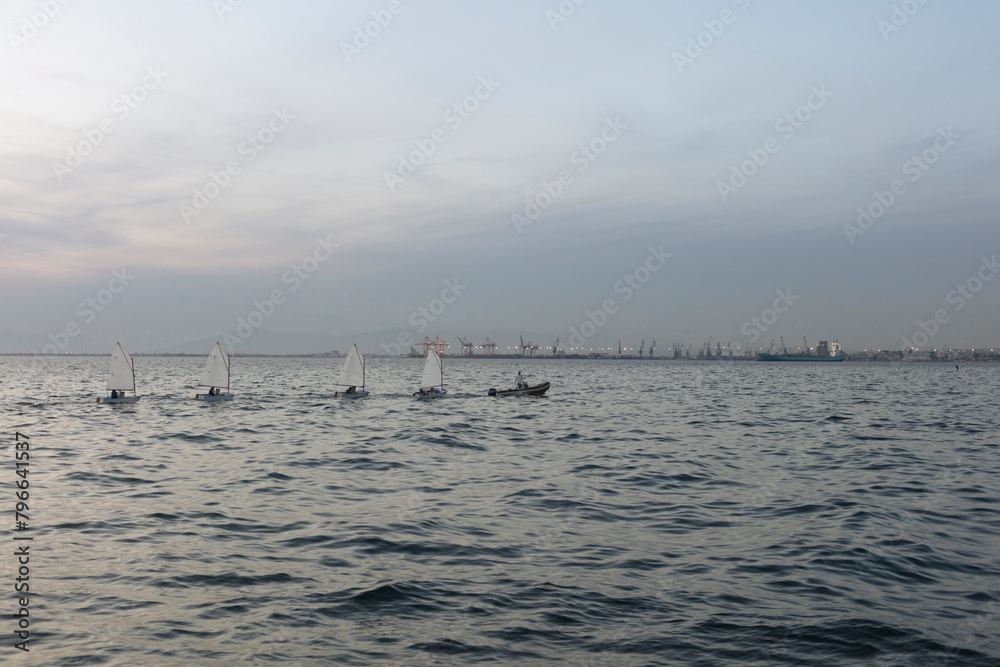 Choppy sea waters under a twilight sky with silhouettes of boats and a distant, faint city skyline at dusk.
Choppy sea waters under a twilight sky with silhouettes of boats and a distant, faint city skyline at dusk.