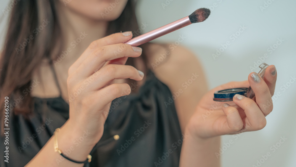 A girl using a makeup brush.