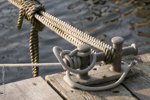 Metal bollard with ropes on a pier