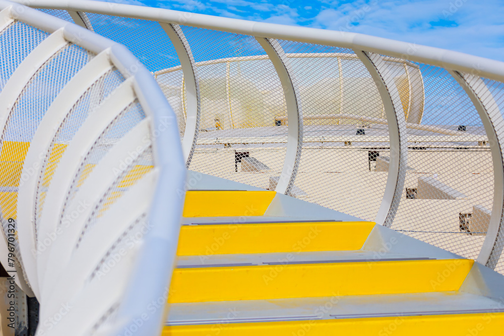 Yellow metal stairs on a sunny day. Staircase on the deck of a cruise ship