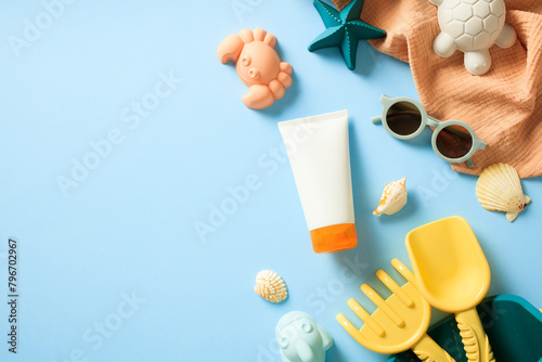 Sunscreen baby cream with sand shapes on blue background. Sunscreen protect for kids concept.