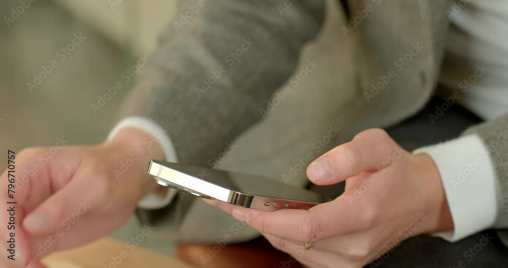 Business life background. Close-up hands of businessperson navigate smartphone and laptop touchpad. Fingers move with precision and speed, tapping and swiping across the screens with practiced ease. Business life background. Close-up hands of businessperson navigate smartphone and laptop touchpad. Fingers move with precision and speed, tapping and swiping across the screens with practiced ease.