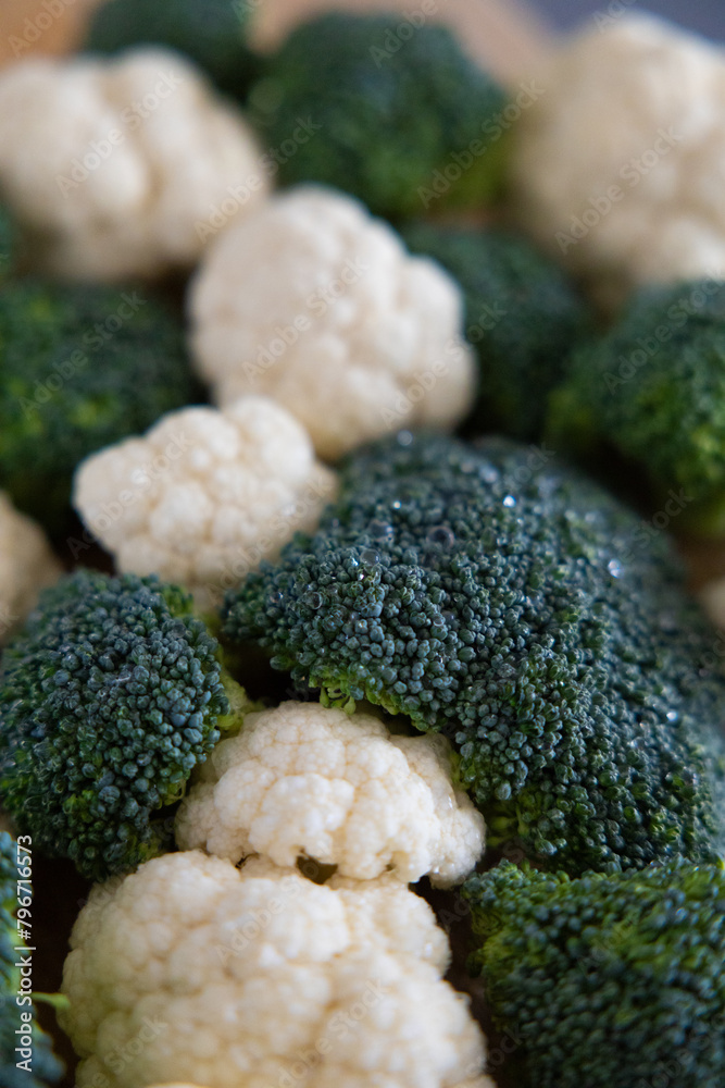 fresh broccoli and cauliflower in a bowl and on the table fresh broccoli and cauliflower in a bowl and on the table