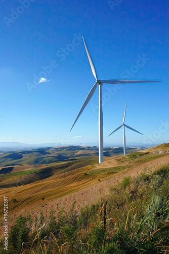Wind turbines on a rolling hill with a clear blue sky, emphasizing sustainable energy sources with a wideopen background for informative captions photo