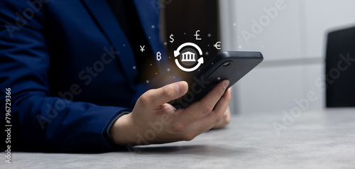 close up investor man hand holding smartphone and trade global currency exchange market by use money transfer application transaction on web for financial and technology with modern lifestyle concept	 photo