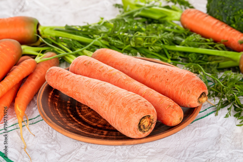 Peeled sweet carrots on the table with vegetables.	