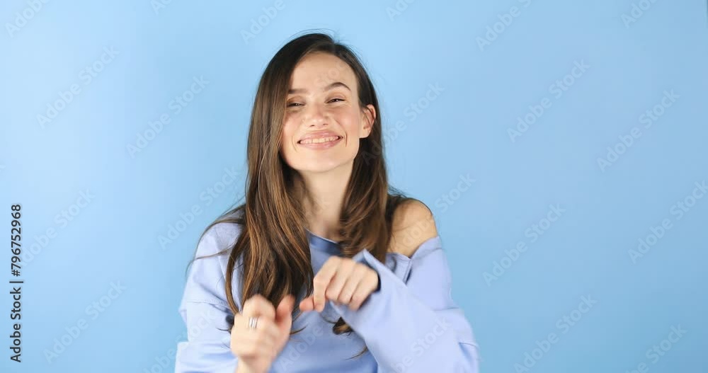 Beautiful cute young woman posing isolated on blue background in studio. People lifestyle concept. Look camera send blow air kiss showing shape heart with hands. Beautiful cute young woman posing isolated on blue background in studio. People lifestyle concept. Look camera send blow air kiss showing shape heart with hands.