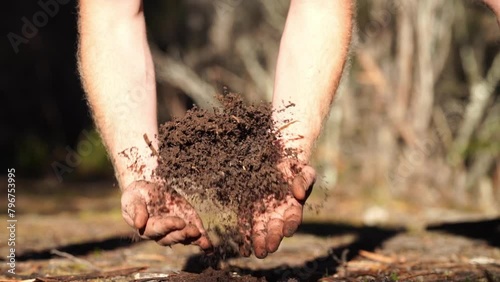 farmer holding soil in hand and pouring soil on ground. connected to the land and environment. soil agronomy in australia. soil heath study. photo