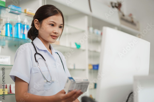 Medicine and health concept, Female pharmacist hold medicine product to working with cash register