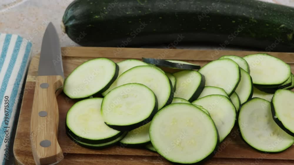 courgettes coupées en morceaux, sur une planche à découper