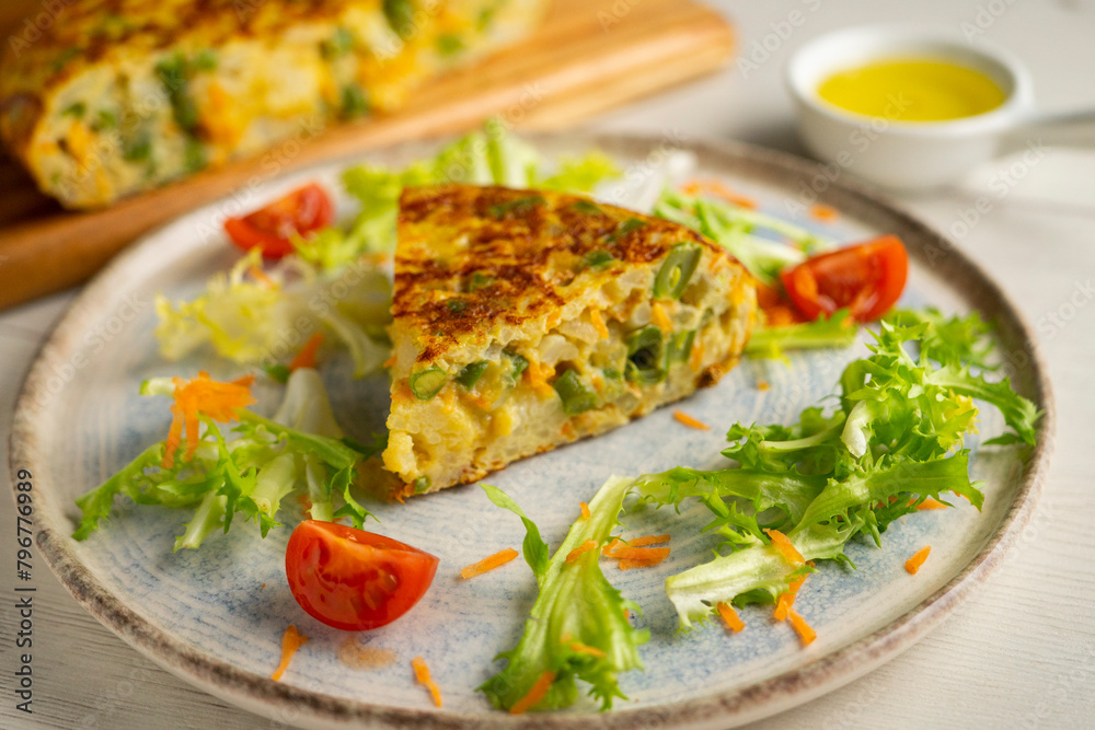 Spanish potato omelet with cauliflower and vegetables. Traditional Spanish tapa recipe.