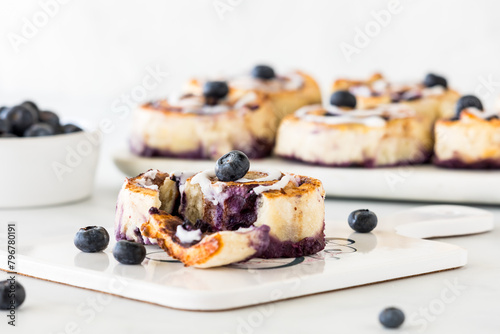 Homemade blueberry cinnamon roll with other rolls in behind.