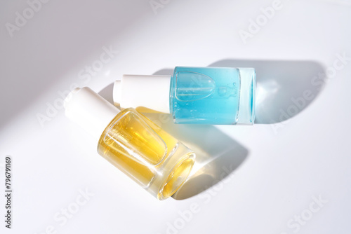 Yellow and blue serums with pipettes against the background of the sun.