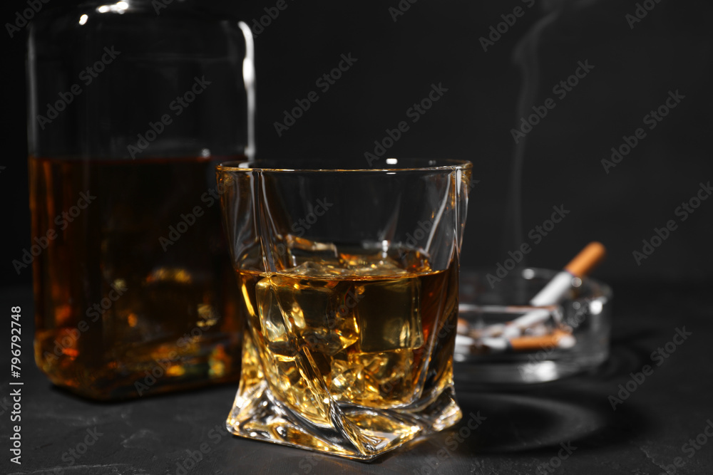 Alcohol addiction. Whiskey in glass on dark textured table, closeup Alcohol addiction. Whiskey in glass on dark textured table, closeup