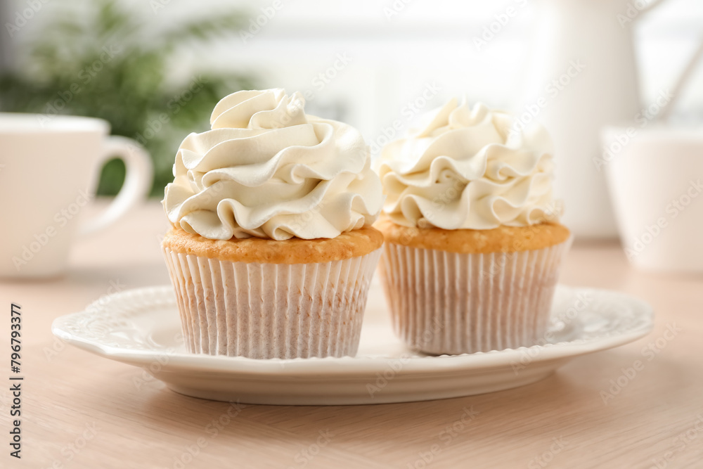 Tasty cupcakes with vanilla cream on light wooden table, closeup