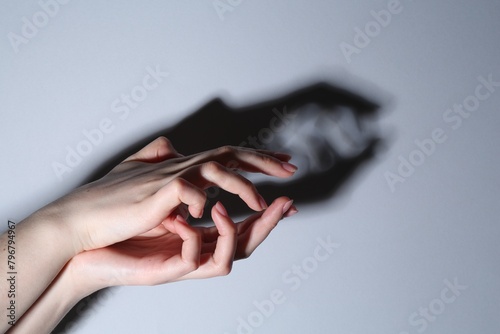 Shadow puppet. Woman making hand gesture like crocodile on grey background, closeup