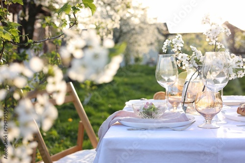 Stylish table setting with beautiful spring flowers in garden