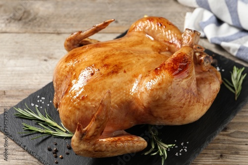 Tasty roasted chicken with spices on wooden table