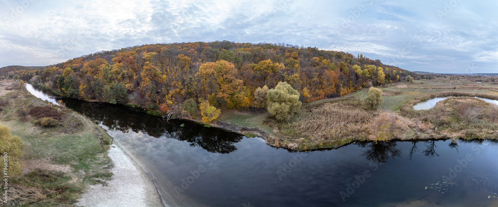 Aerial wide panorama of river valley with autumn forest and grey cloudy sky in Ukraine countryside