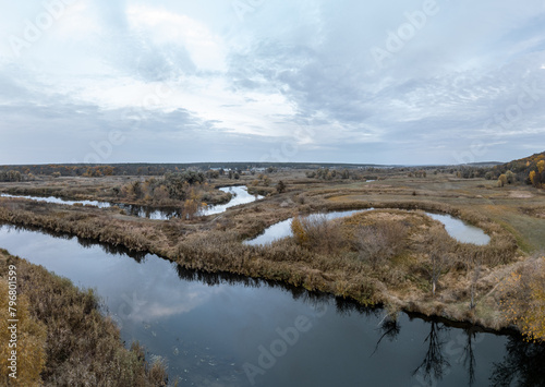 Autumn river with bare trees and cloudy evening sky in rural Ukraine