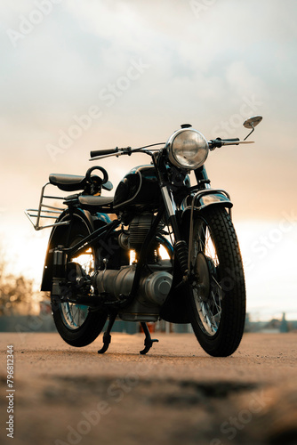 Vintage motorcycle, classic retro motorbike, black antique old bike at sunset