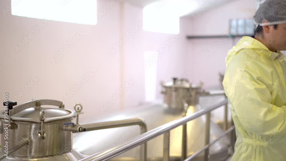 quality control officer is inspecting and checking food and beverage production machinery inside the manufacturing plant. quality control officer is inspecting and checking food and beverage production machinery inside the manufacturing plant.