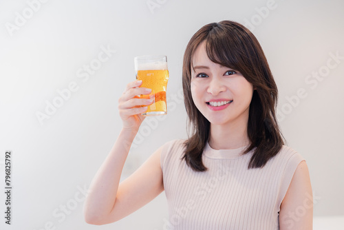 笑顔でビールを飲む若い女性