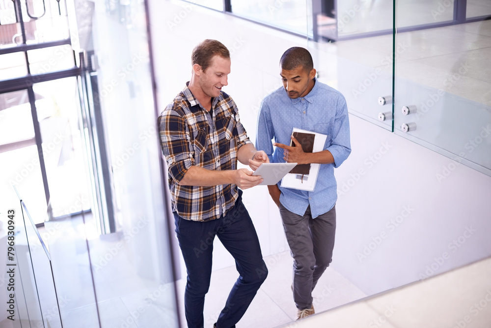 © peopleimages.com - People, employees and office with tablet on stairs for online research, ideas and creativity as graphic designers. Teamwork, collaboration and internet for networking and communication and discussion