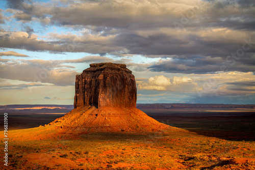 Merrick's Butte in Monument Valley during sunset shows a dramatic view with the setting sun and remaining scattered storm clouds. photo