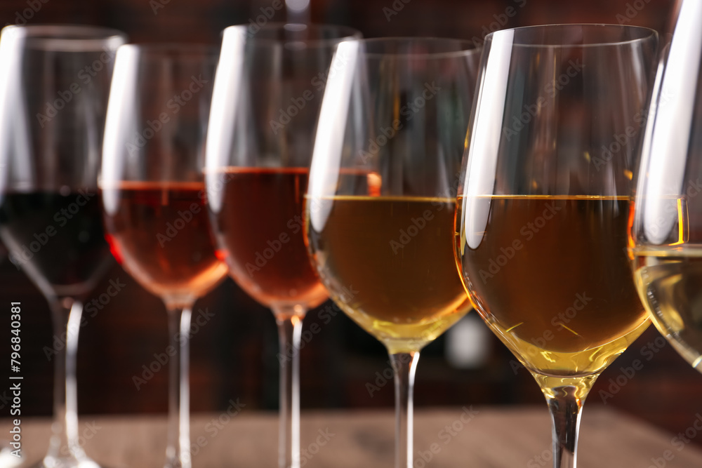 Obraz premium Different tasty wines in glasses against blurred background