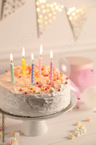 Tasty Birthday cake with burning candles on white table  closeup