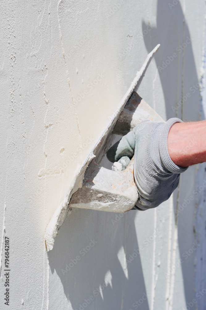 Man at work put mortar on top mesh to plaster interior construction site wall with protective gloves, blank space on wall. Man at work put mortar on top mesh to plaster interior construction site wall with protective gloves, blank space on wall.