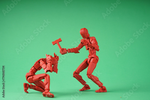 Conceptual photo of the conflict.
Two human figurines enact a fight scene. One figure holds a hammer, the other covers his head with his hands.