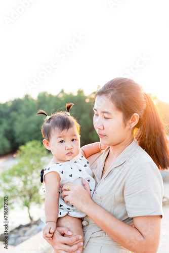 Mother and child playing in the park,Beautiful Asian mother and child play happily in outdoor amusement park, Mother's Day concept.